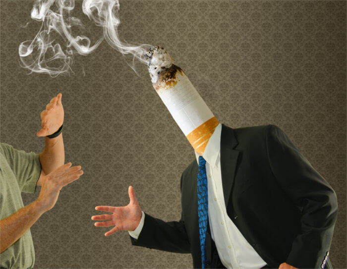 Mann mit qualmender Zigarette als Kopf versucht sozial zu sein